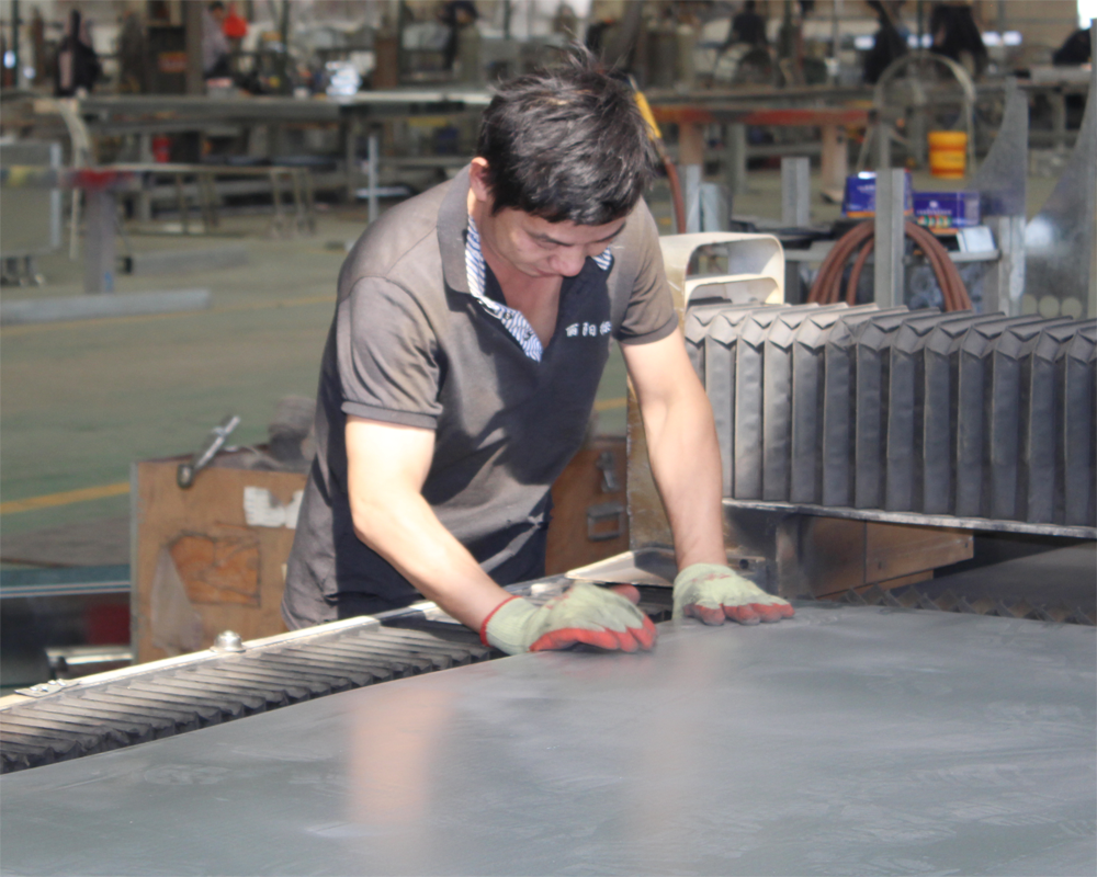 Factory worker cutting metal sheet for outdoor products