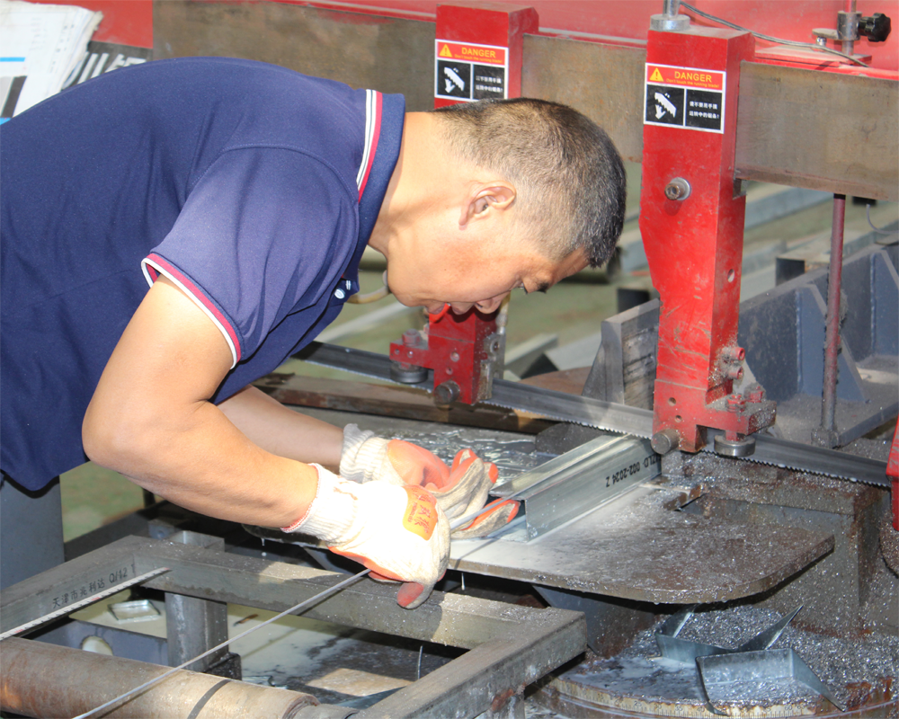 Factory worker grinding metal component during production