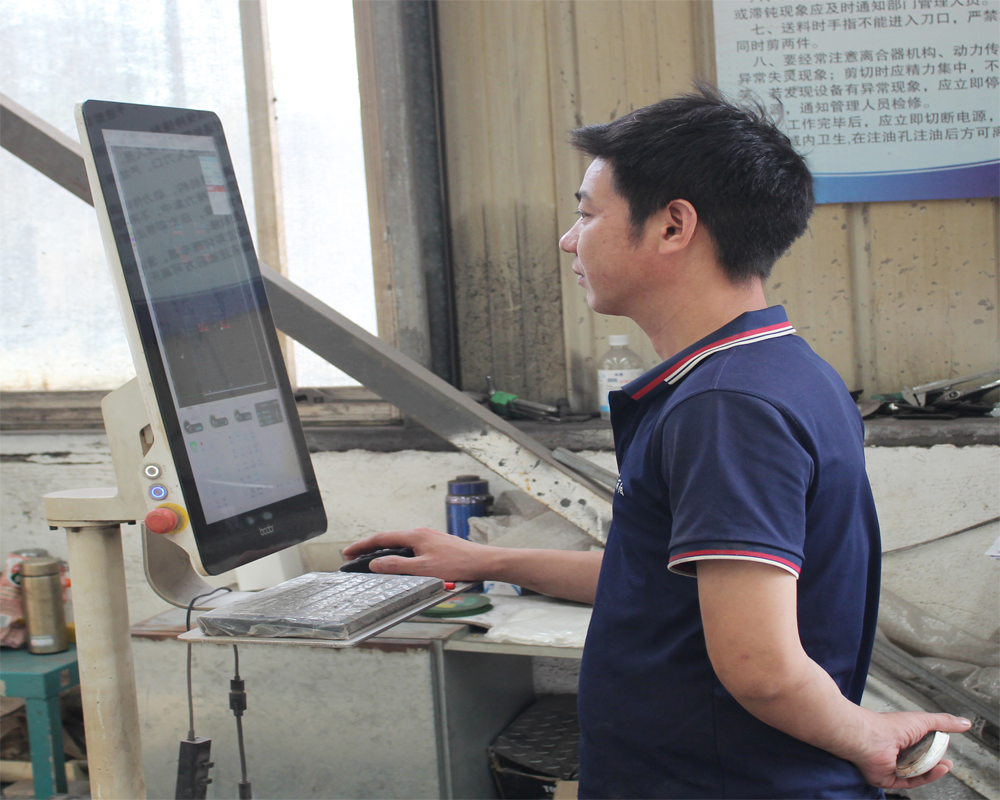 Factory staff reviewing product design work on computer
